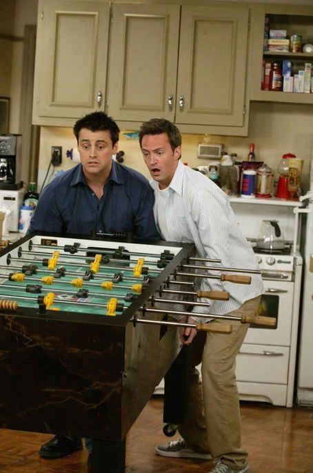 Joey and Chandler from Friends playing table foosball